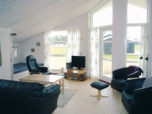 A spacious living area with a sofa, a television, and a table. - 4 Star Holiday Home in Rudkobing (Rudkobing)