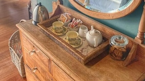 A wooden dresser with drawers, a mirror, and a tray with cups and a teapot. - The Seaglass (Durban)