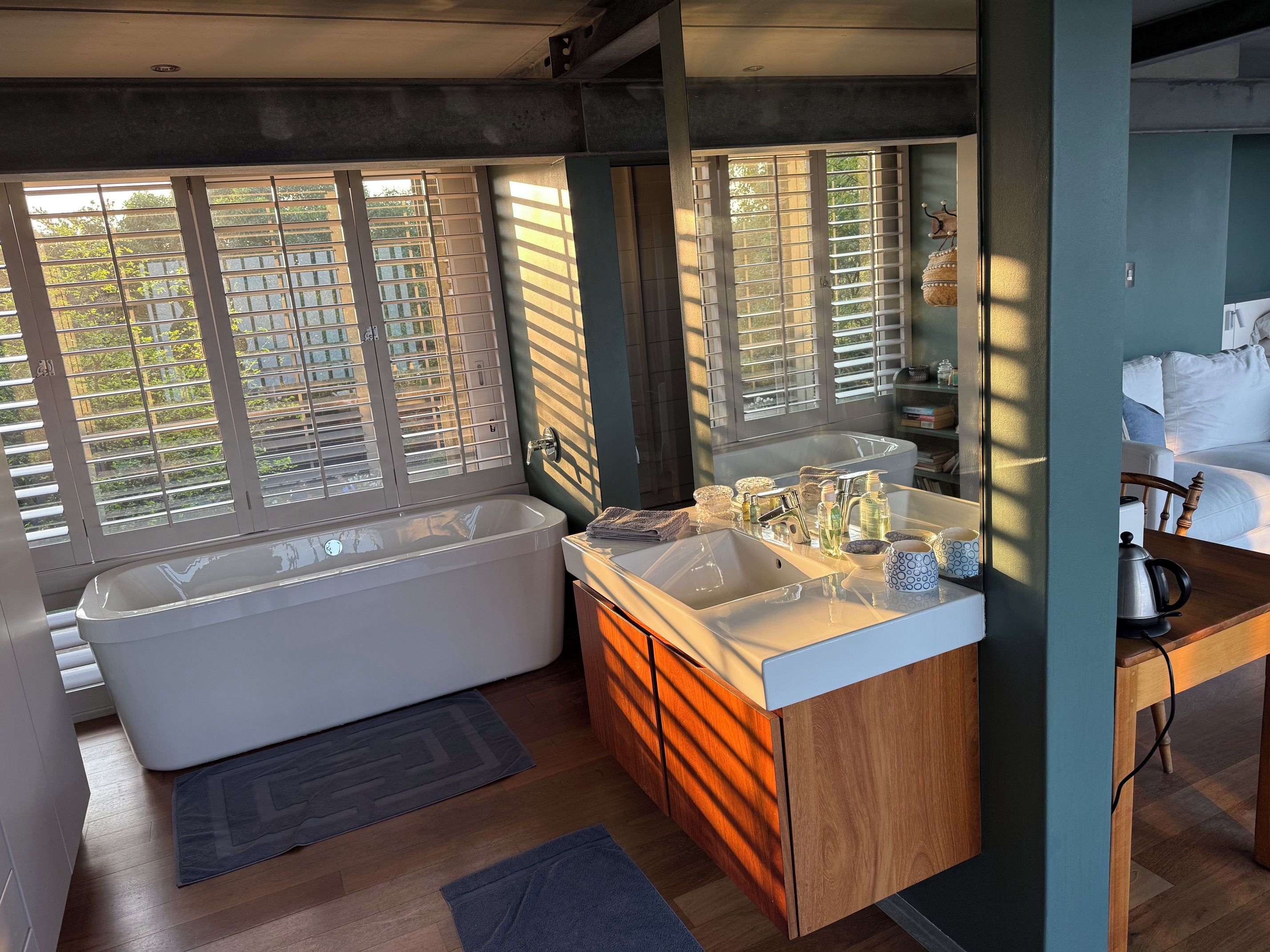 A modern bathroom with a freestanding bathtub, dual sinks, and a vanity with storage.