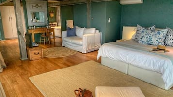 Quarto com cama, dois sofás, escrivaninha e uma cadeira.
