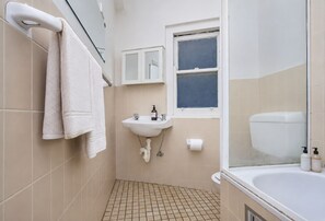 A bathroom with a sink, toilet, and bathtub. - Potts Point Cosy 1BR | Walk to CBD, Train, Cafes & Harbour! (Potts Point)