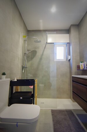A modern bathroom with a shower, toilet, and a small window. - Entire Cascais New Mordern Apartment-3 Bedrooms (Cascais)