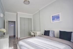 A bedroom with a bed, a desk, and a wardrobe. - Entire Cascais New Mordern Apartment-3 Bedrooms (Cascais)