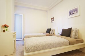 A bedroom with two beds, a desk, and a door leading to another room. - Entire Cascais New Mordern Apartment-3 Bedrooms (Cascais)