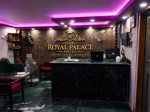 A reception area with a marble counter, a statue, and a sign reading 'TRP The Royal Palace Hotel'. - Hotel The Royal Palace (Lucknow)