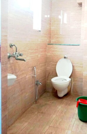 Um banheiro pequeno com vaso sanitário, chuveiro e pia.