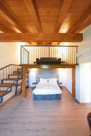 A room with a loft bed, a staircase, and a small table. - New Farmhouse TENUTA MARELLA immersed in the Green at the gates of Rome (Lazio)