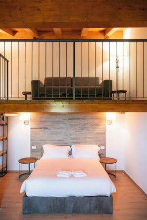 A hotel room with a bed, two bedside tables, a wooden ceiling, and a balcony with seating. - New Farmhouse TENUTA MARELLA immersed in the Green at the gates of Rome (Lazio)