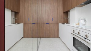 Una cucina moderna con mobili in legno, un piano di lavoro bianco e un forno integrato.