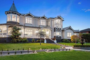A large, multi-story house with a prominent tower, a well-maintained lawn, and a fountain. - Kirinaran Manor Pool & Bar Room (Frankston South)