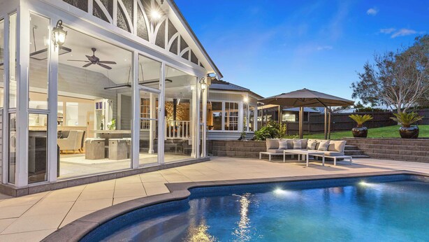 A modern house with a swimming pool, glass doors, and outdoor furniture. - Kirinaran Manor | Pool & Games Room (Frankston South)