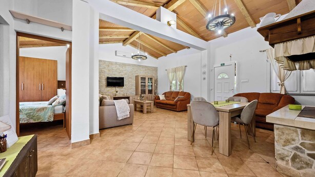 A spacious living area with a dining table, sofas, and a kitchen area. - Holiday Home Villa Le Punte (Rovinj)