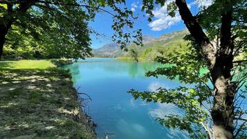 A serene lake surrounded by lush greenery and mountains.
