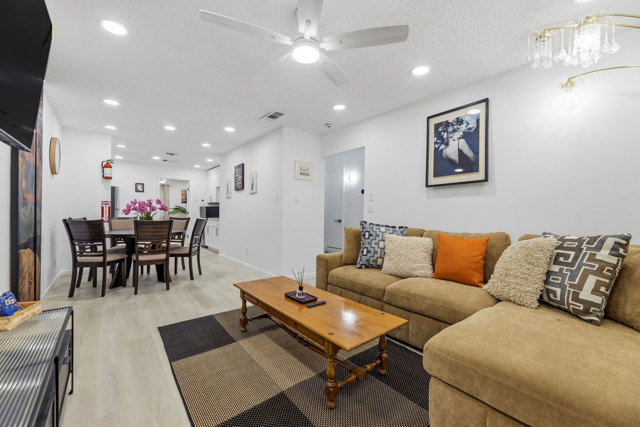 A living room with a sofa, coffee table, and dining area with chairs.