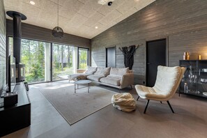 A modern living room with a sofa, ottoman, and a television.