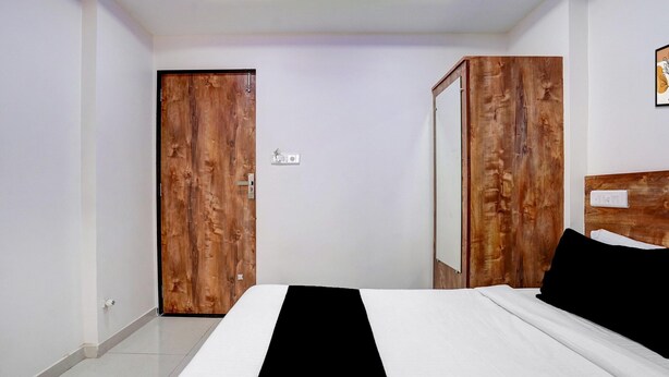 A bedroom with a bed, a wardrobe, and a door.
