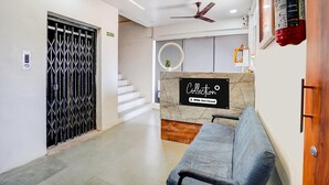 A reception area with a marble counter, a ceiling fan, and a fire extinguisher.