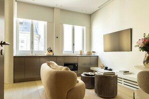 Una cucina moderna con forno integrato, un'area pranzo con tavolo rotondo e un'ampia finestra che offre luce naturale.