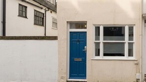 Un edificio a due piani con una porta blu e una finestra.