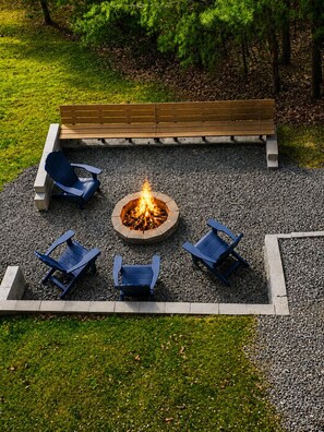 A fire pit surrounded by four Adirondack chairs, with a wooden bench above. - Large Pet Friendly Home! Games, Firepit & More! (Sevierville)