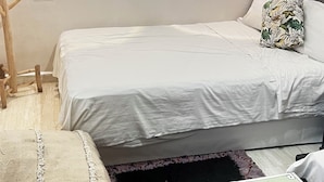 A bedroom with two beds, a wooden chair, a small table, and a decorative pillow. - Riad Dar Lokman (Marrakech)