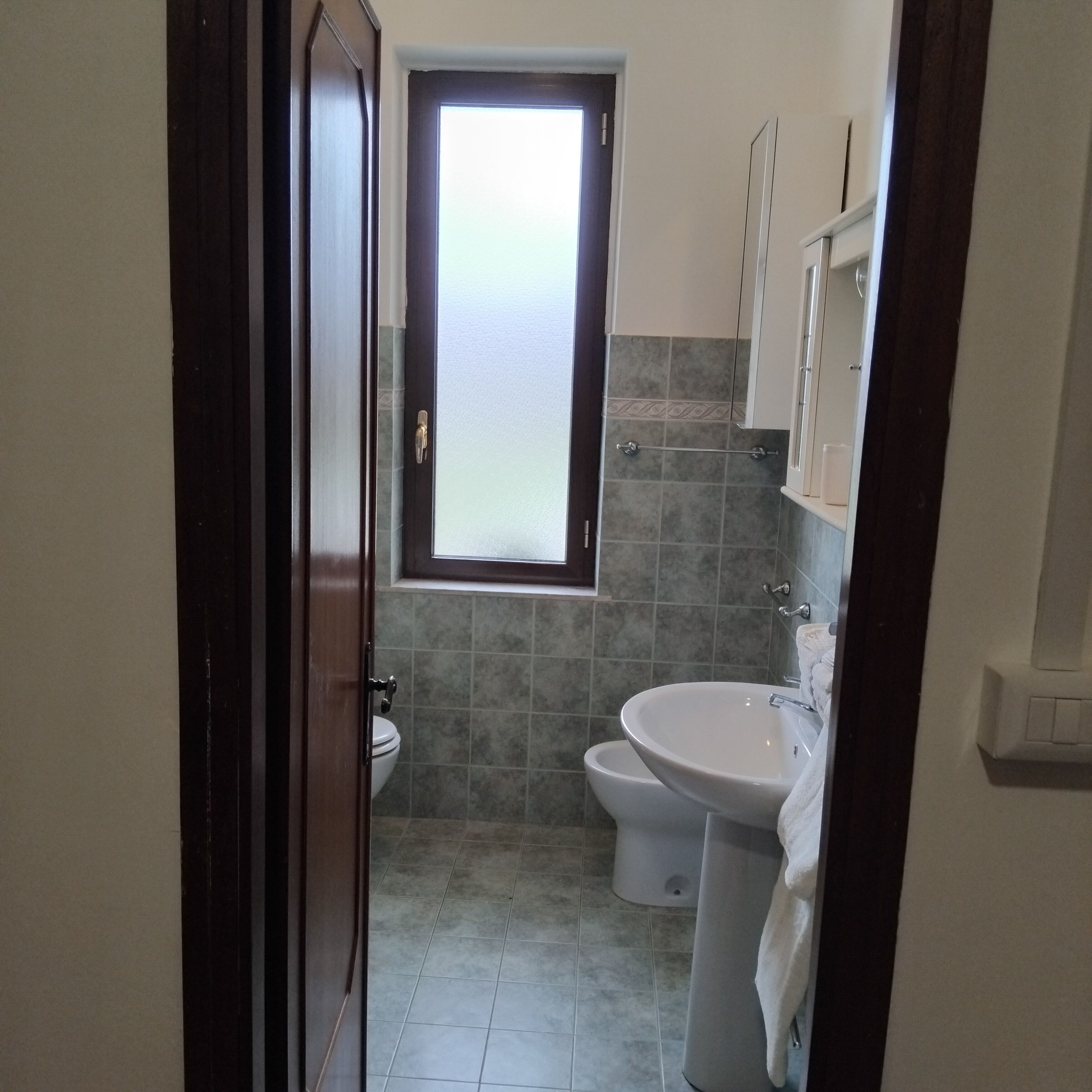 A bathroom with a toilet, bidet, and sink.