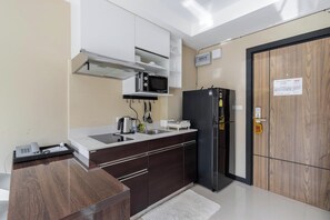 Eine moderne Küche mit Mikrowelle, Kühlschrank und Telefon auf der Arbeitsfläche.