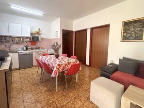 Ein kompakter Wohnbereich mit Essplatz, Küchenzeile und Sofa.