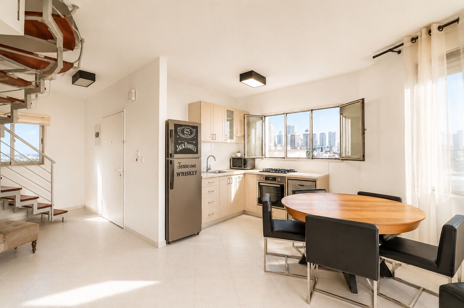 A modern kitchen with a built-in refrigerator, a dining table with chairs, and a city view through large windows.