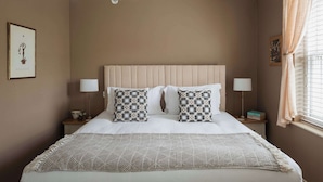 A neatly arranged bedroom with a large bed, two bedside tables, a chandelier, and a window with curtains. - The Monmouth House of Bath (Bath)