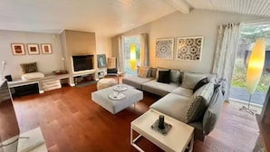 A living room with a sofa, a coffee table, a TV, and artwork on the walls. - 4 Star Holiday Home in Nykobing Sj (Nykobing Sjaelland)