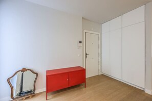 Una habitación con un armario rojo, una puerta blanca y un vestidor amplio.