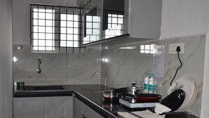 Una cocina con encimera de mármol, un fregadero y un ventanal pequeño.