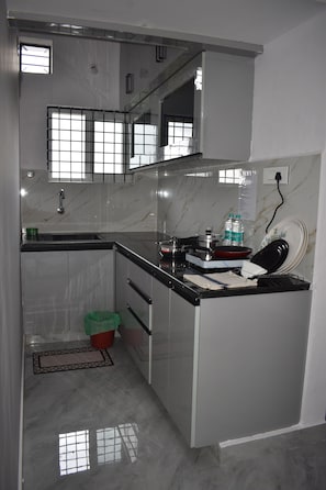 Eine Küche mit Marmorarbeitsplatte, einem Spülbecken und einem kleinen Fenster.