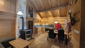 Ein Blockhaus-Interieur mit Küche, Essbereich und Kamin.
