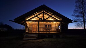 A log cabin with a porch, a door, and a window. - Cozy log cabin with terrace and stunning views (Haidmühle)