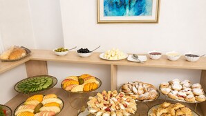 A buffet with various food items and a painting on the wall. - Astoria Boutique (Tashkent)