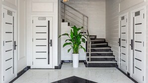A hotel lobby with a marble floor, a staircase, and a potted plant. - Astoria Boutique (Tashkent)