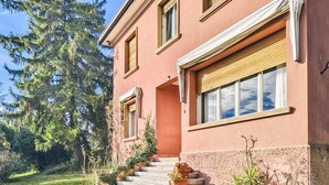 A two-story building with a stone staircase leading to the entrance, surrounded by greenery and trees. - Villa Marina - Immersed in Nature (Cavaso del Tomba)