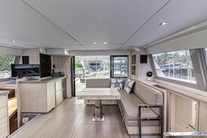 Un interior moderno con área de cocina, asientos y ventanas amplias.