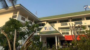 A multi-story building with a green roof, a sign with 'NJ' on the front, and a red awning. - NJ INTHAI HOTEL (Khlong Luang)