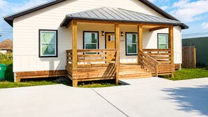 A single-story house with a front porch, a garage, and a clear sky. - 3 BD Family Home | Extd Stays | Pets Ok (Aransas Pass)