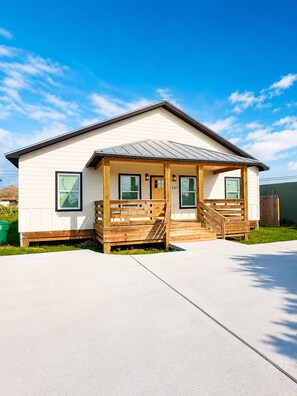 A single-story house with a front porch, a garage, and a clear sky. - 3 BD Family Home | Extd Stays | Pets Ok (Aransas Pass)