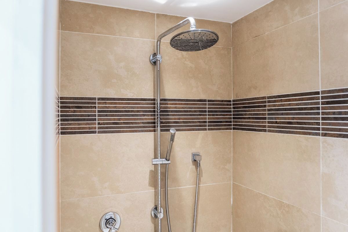 Eine Dusche mit Duschbrause und zwei Handbrausen.