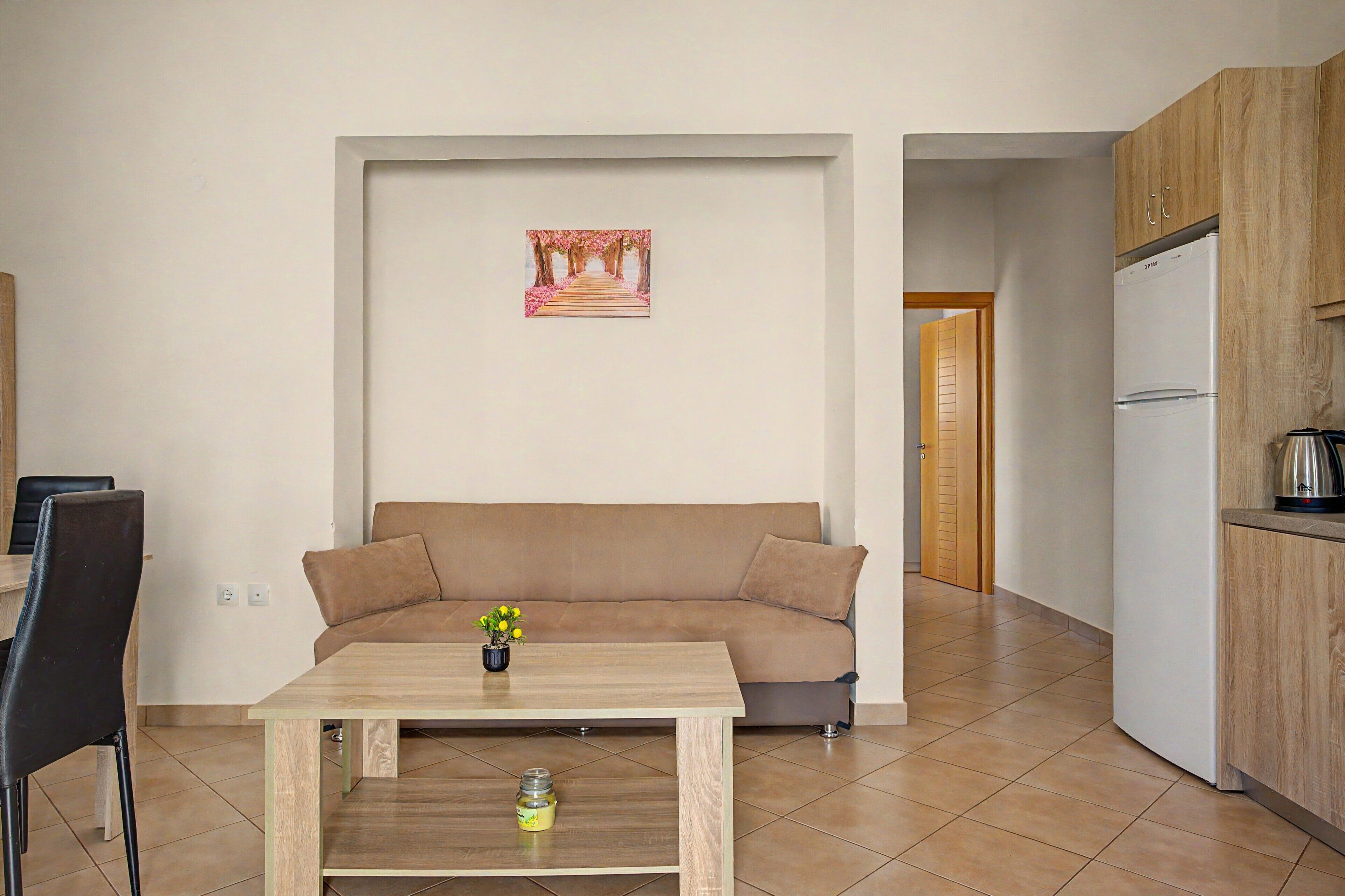 A living room with a sofa, a coffee table, and a painting on the wall.