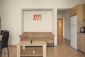 Una sala de estar con un sofá, una mesa de centro y un cuadro en la pared.
