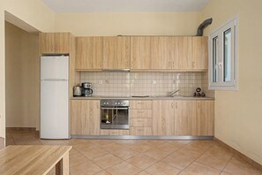 A compact kitchen with wooden cabinets, a built-in oven, and a refrigerator.