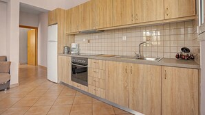 Een moderne keuken met houten kastjes, een roestvrijstalen spoelbak en een ingebouwde oven.