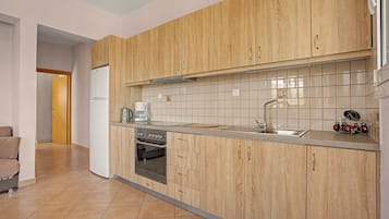 A modern kitchen with wooden cabinets, a stainless steel sink, and a built-in oven.