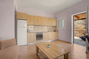 Une cuisine compacte avec des meubles en bois, un four encastré et un réfrigérateur.